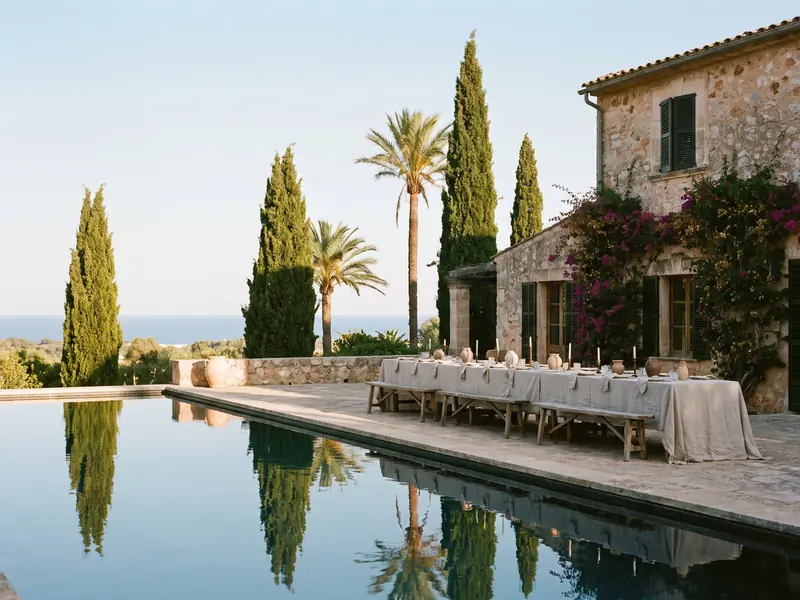 A wedding lunch table under a stone pergola overlooking the sea